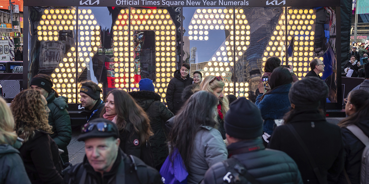 Människor poserar framför 2024 års nyårssiffror som visas på Times Square, onsdagen den 20 december 2023, i New York.