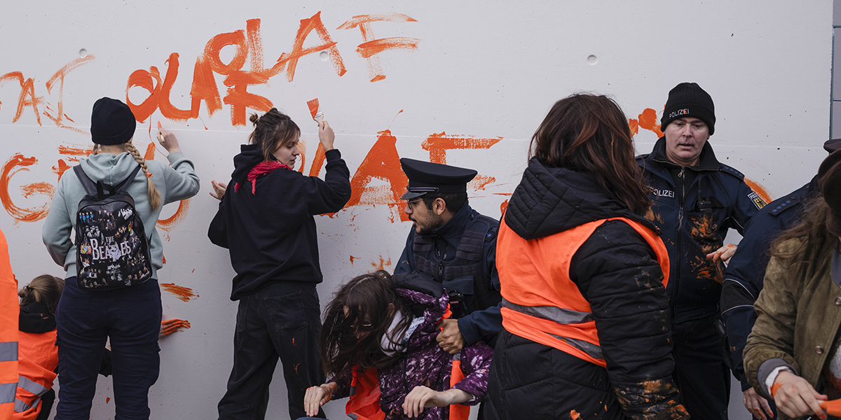 Poliser försöker stoppa aktivister från Letzte Generation från att måla slagord på framsidan av kanslihuset i Berlin under en klimatprotest mot regeringens klimatpolitik, 31 oktober 2023.