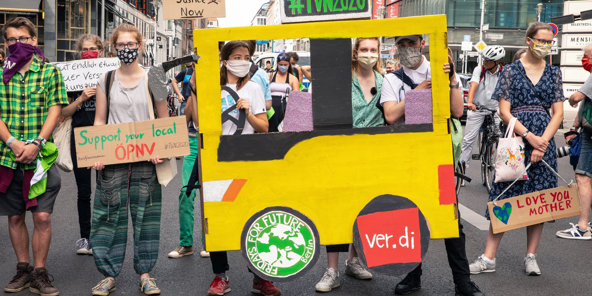 Protest med buss tillverkad av kartong.