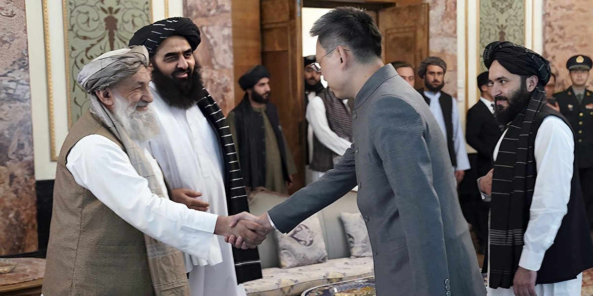 Kinas nya ambassadör till Afghanistan Zhao Sheng skakar hand med talibanernas premiärminister Mohammad Hasan Akhund.