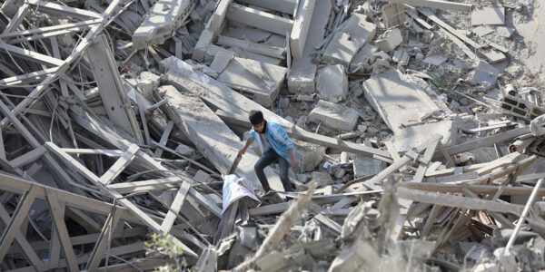 Ensamt barn bland rasmassor i i staden Gaza.