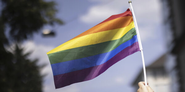 Regnbågsflagga hålls upp av en hand