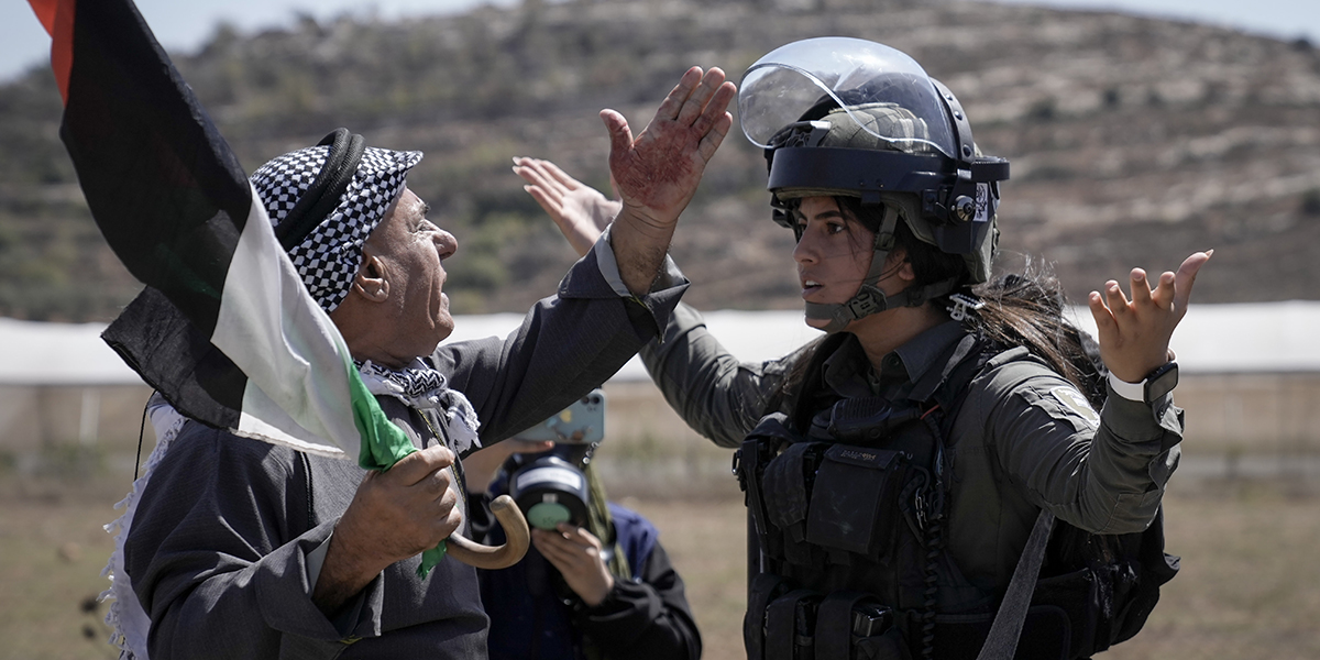 En palestinsk demonstrant argumenterar med israeliska säkerhetsstyrkor för att förhindra att tårgas skjuts mot palestinska demonstranter under en demonstration mot israeliska bosättningar i byn Qaryout, nära staden Nablus på Västbanken, september 2023.