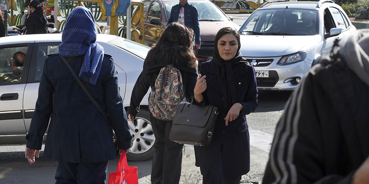 En ung iransk kvinna utan huvudduk på trafikerad gata