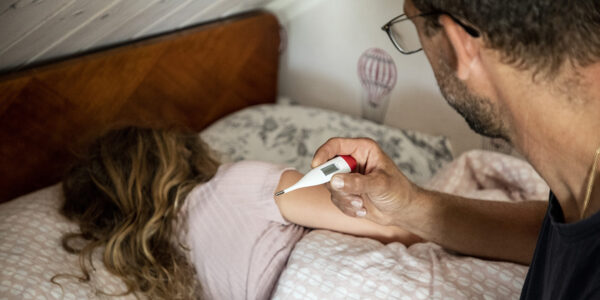 en man läser av tempen hos sjukt barn