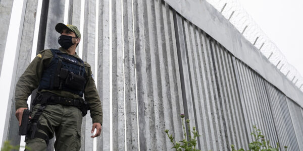 En polis patrullerar längs stålmuren som skiljer Grekland från Turkiet.