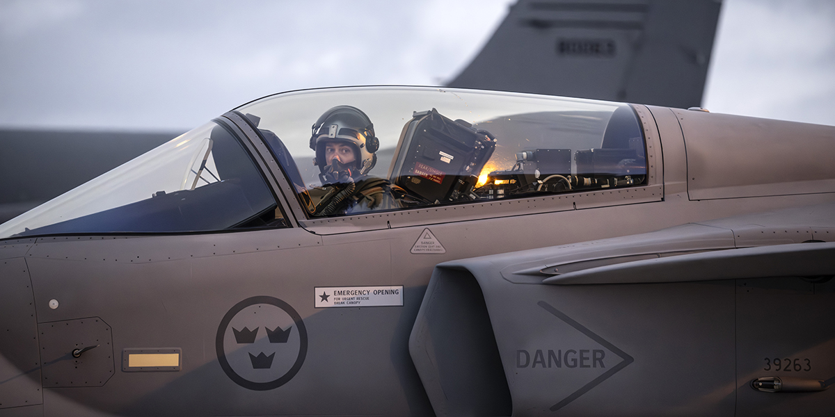 Pilot tittar ut ur ett militärflygplan