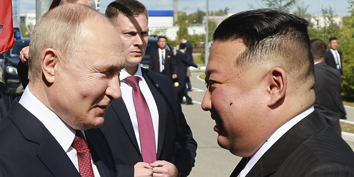 Vladimir Putin och Kim Jong-Un tittar på varandra leendes