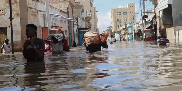 Människor vadar i vatten efer översvämningar