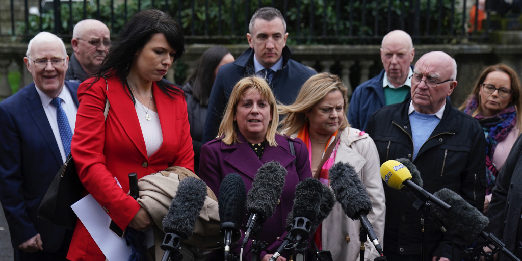 Människor står inför flera mikrofoner och ger kommentarer utanför en domstol i Belfast.