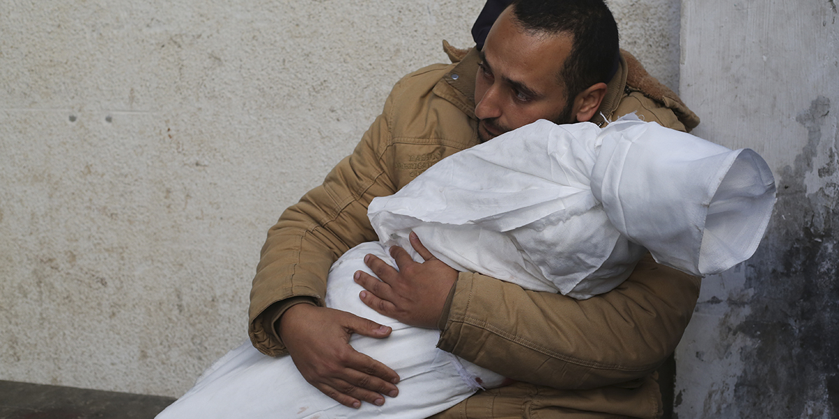 En palestinier håller sitt barn som dödats i israeliska bombräd