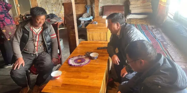 Tre män pratar i köket