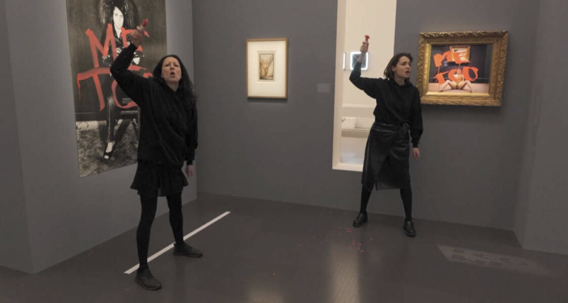 två kvinnor spraymålar tavla på museum