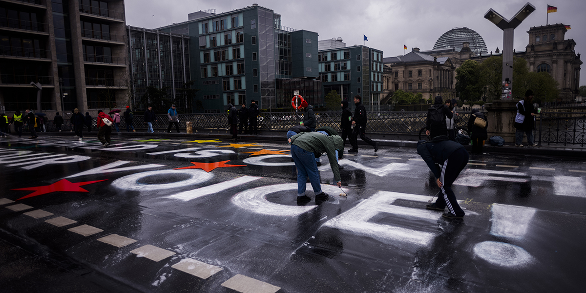 Aktivister från rörelsen Fridays For Future målar sloganen &#039;Our World Is On Fire - Use Your Voice&#039; på Marschall-bron i Berlin, Tyskland,