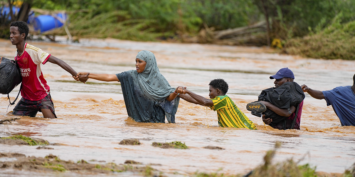 Invånare korsar en väg som skadats av El Niño-regnen