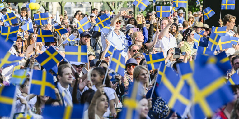 folksamling med svenska flaggor