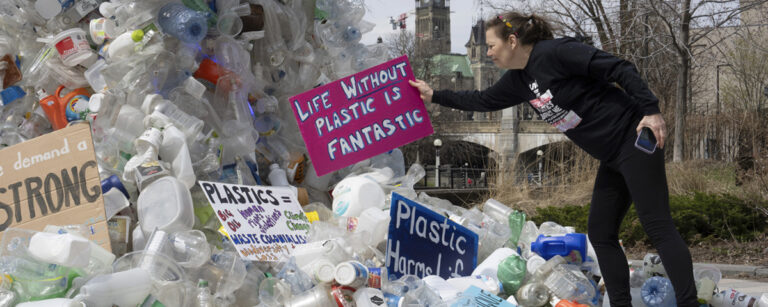 kvinna placerar plakat på plastsopor