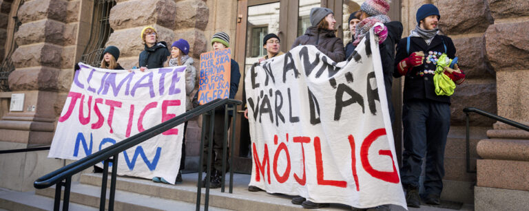 Klimataktivister protesterar utanför riksdagen.