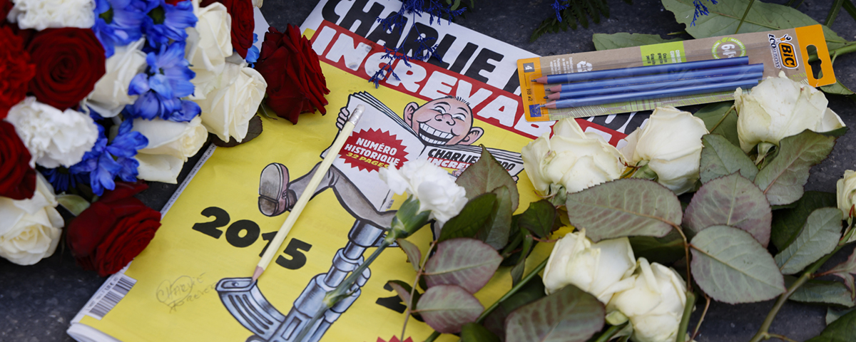 satirtidningen Charlie Hebdo ligger bland kransar och pennor som l