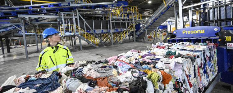 kvinna vid textilåtervinningsmaskin