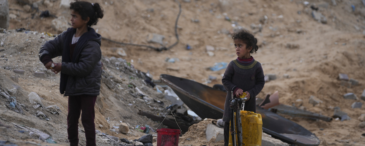 Två palestinska barn hämtar vatten vid en skola som drivs av FN:s hjälporganisation för palestinska flyktingar, UNRWA, väster om Gaza city, 9 mars 2025.