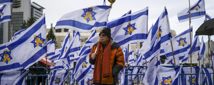 Man omgiven av israeliska flaggor