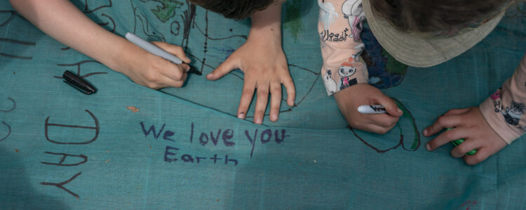 Barnhänder skriver meddelanden på tyg