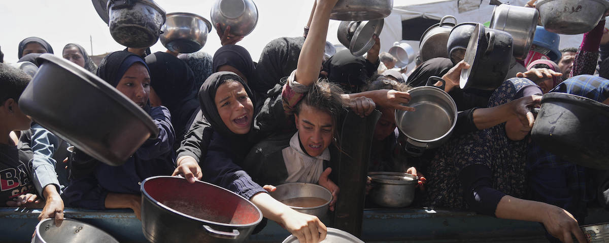 Palestinier kämpar för att komma över mat i ett gemensamt kök för behövande i Khan Younis på Gazaremsan, 5 maj 2025.