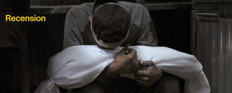 man sörjer med sitt döda barn i famnen