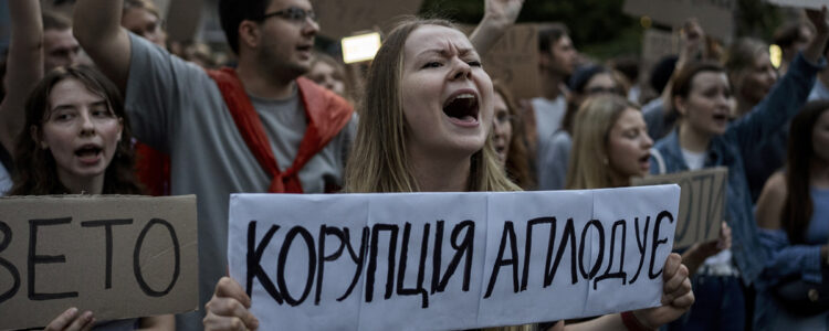demonstration med kvinna med banderoll som skriker
