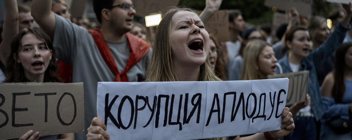 demonstration med kvinna med banderoll som skriker