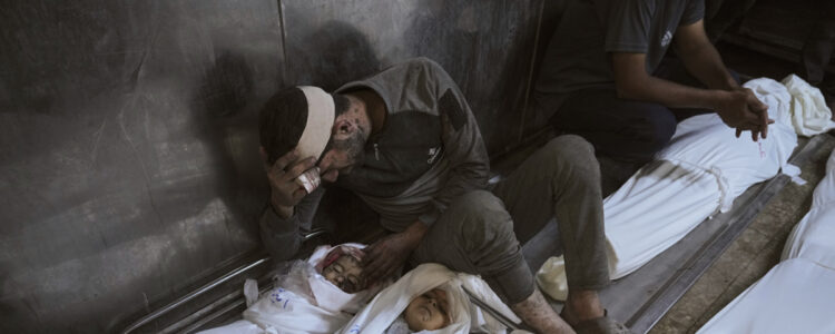 man sörjer sitt döda barn som är inlindat