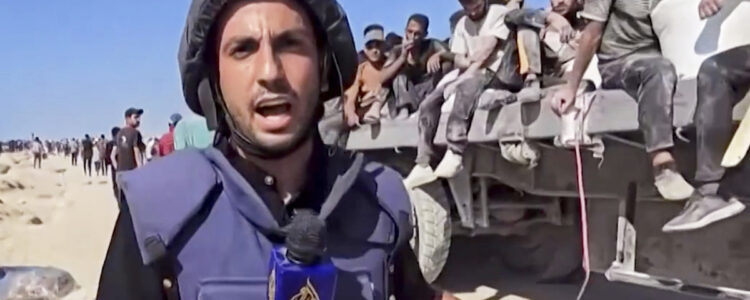 man pratar i mikrofon med hjälm och skyddsväst