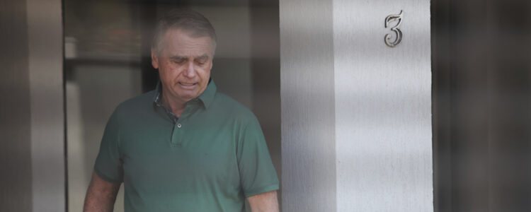 Jair Bolsonaro står vid ingången till sitt hem