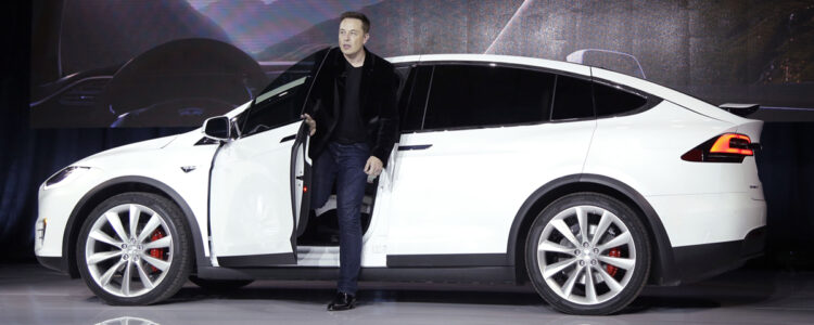 Elon Musk framför en Tesla.