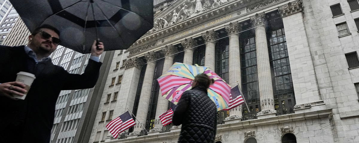 två personer med paraply framför hus