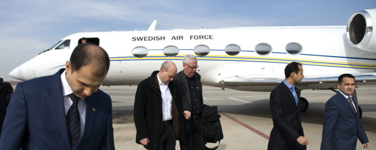 personer i kostym framför flygplan