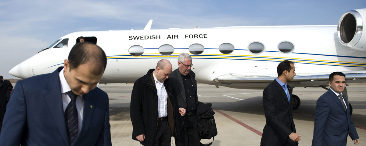 personer i kostym framför flygplan