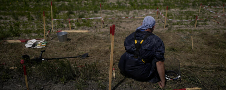 man sitter och desarmerar minor
