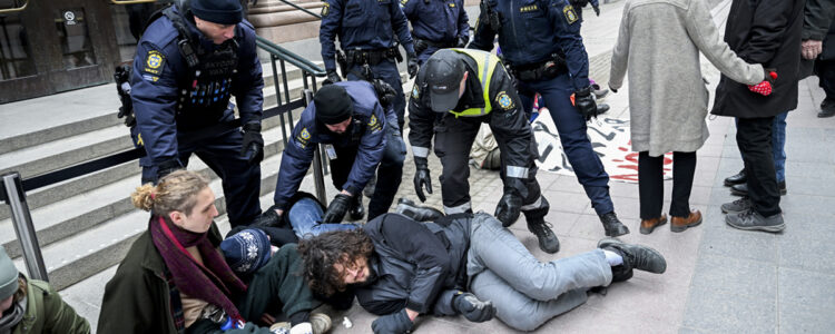 Polisen bär bort demonstranter ur en grupp klimataktivister