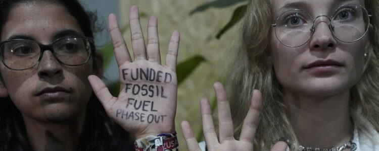 två kvinnor med skrivet budskap i händerna