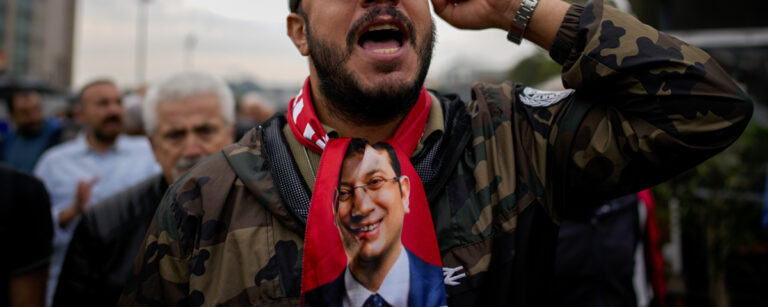 demonstrant med slips föreställande Ekrem Imamoglu