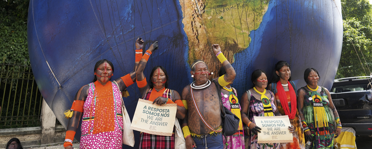 människor protesterar framför stor jordglob