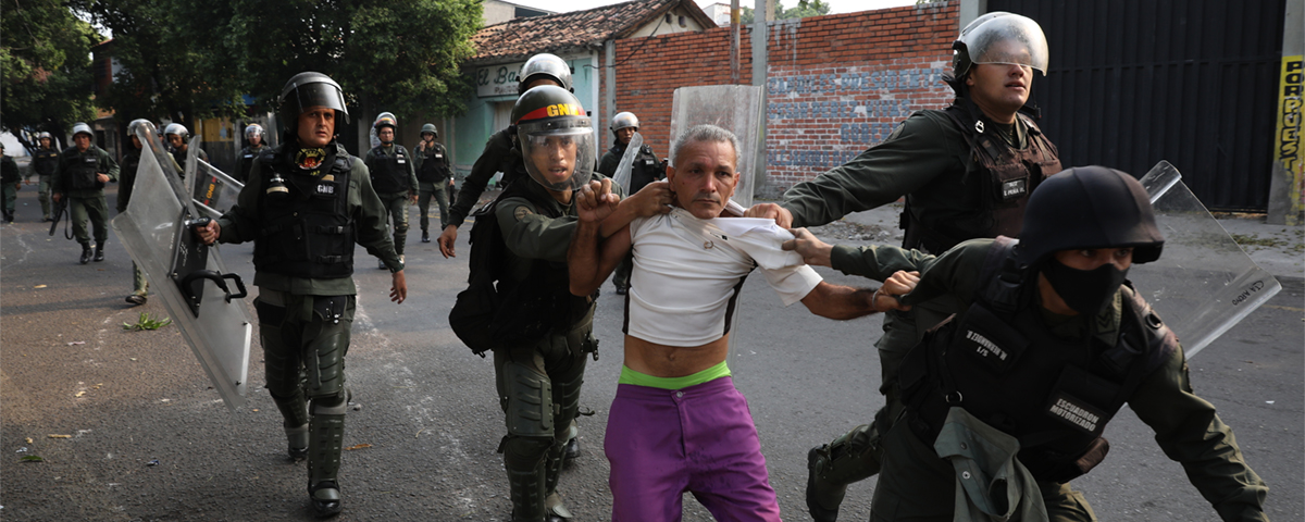 man grips av militärpoliser