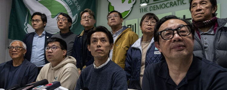 människor sitter på podie vid presskonferens