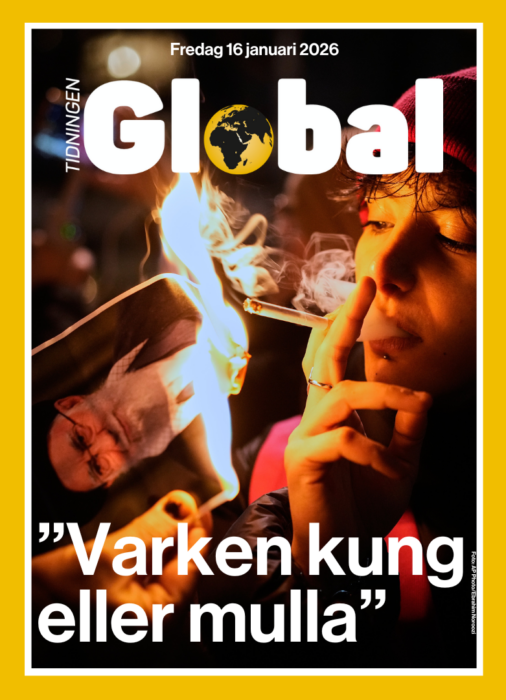 Demonstrant tänder cigarett på en brinnande biild av Ali Khamenei