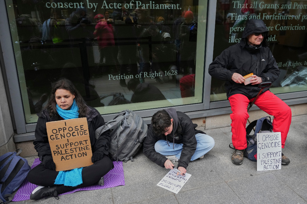 Demonstranter sitter ner och protesterar mot folkmord och till stöd för gruppen Palestine Action.
