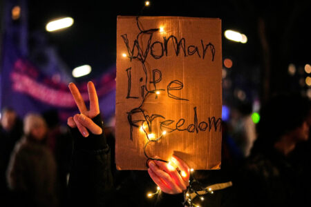 Plakat med orden Kvinna, liv, frihet och v-tecknet.