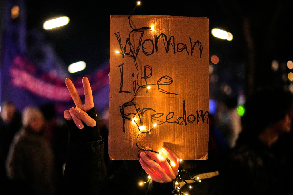 Plakat med orden Kvinna, liv, frihet och v-tecknet.