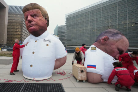 Aktivister jobbar med två uppblåsbara dockor av Donald Trump och Vladimir Putin.